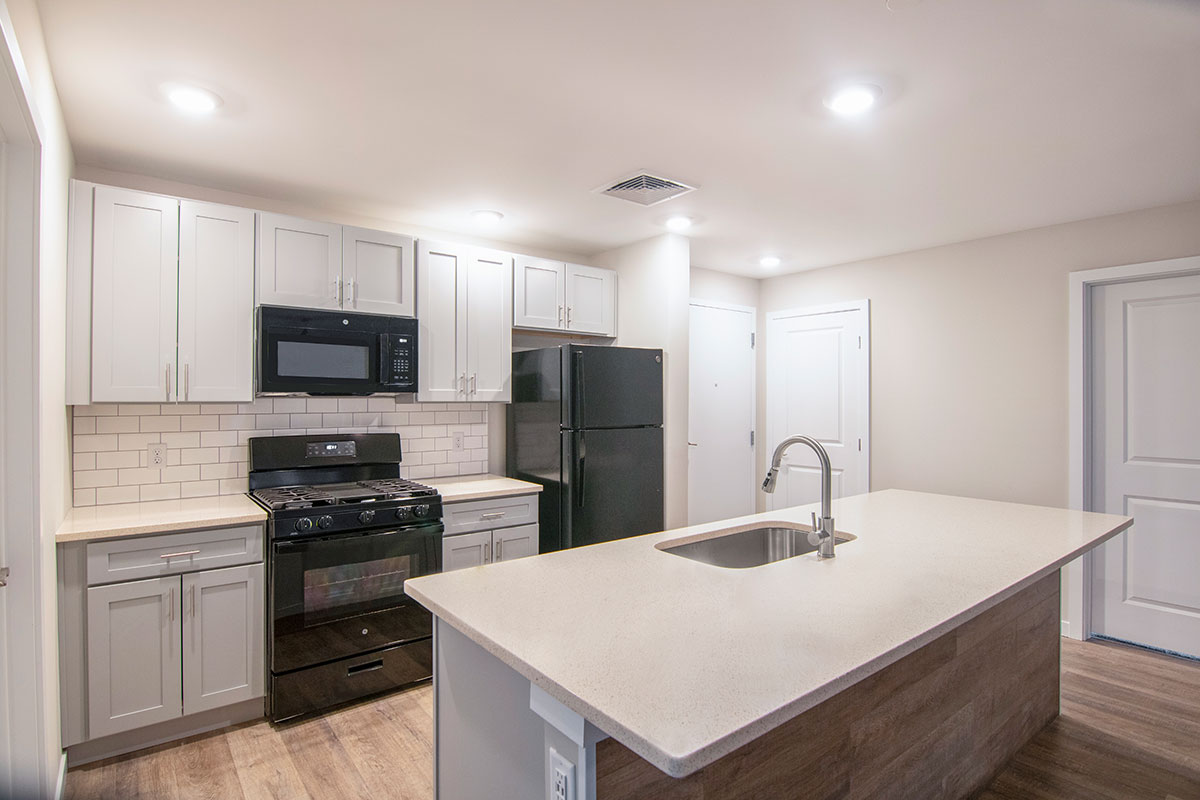 A Kitchen with White Cabinets and a Black Refrigerator